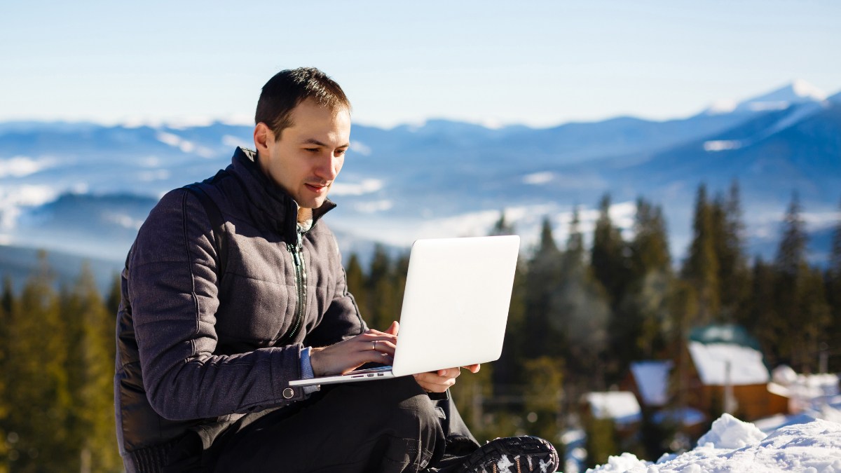 man outdoor looking on his laptop